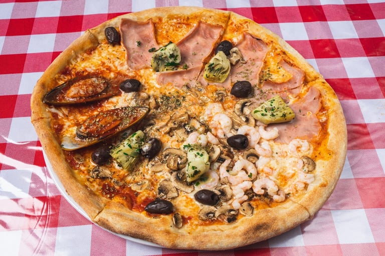 Divided pizza with different toppings on a red and white checkered tablecloth background